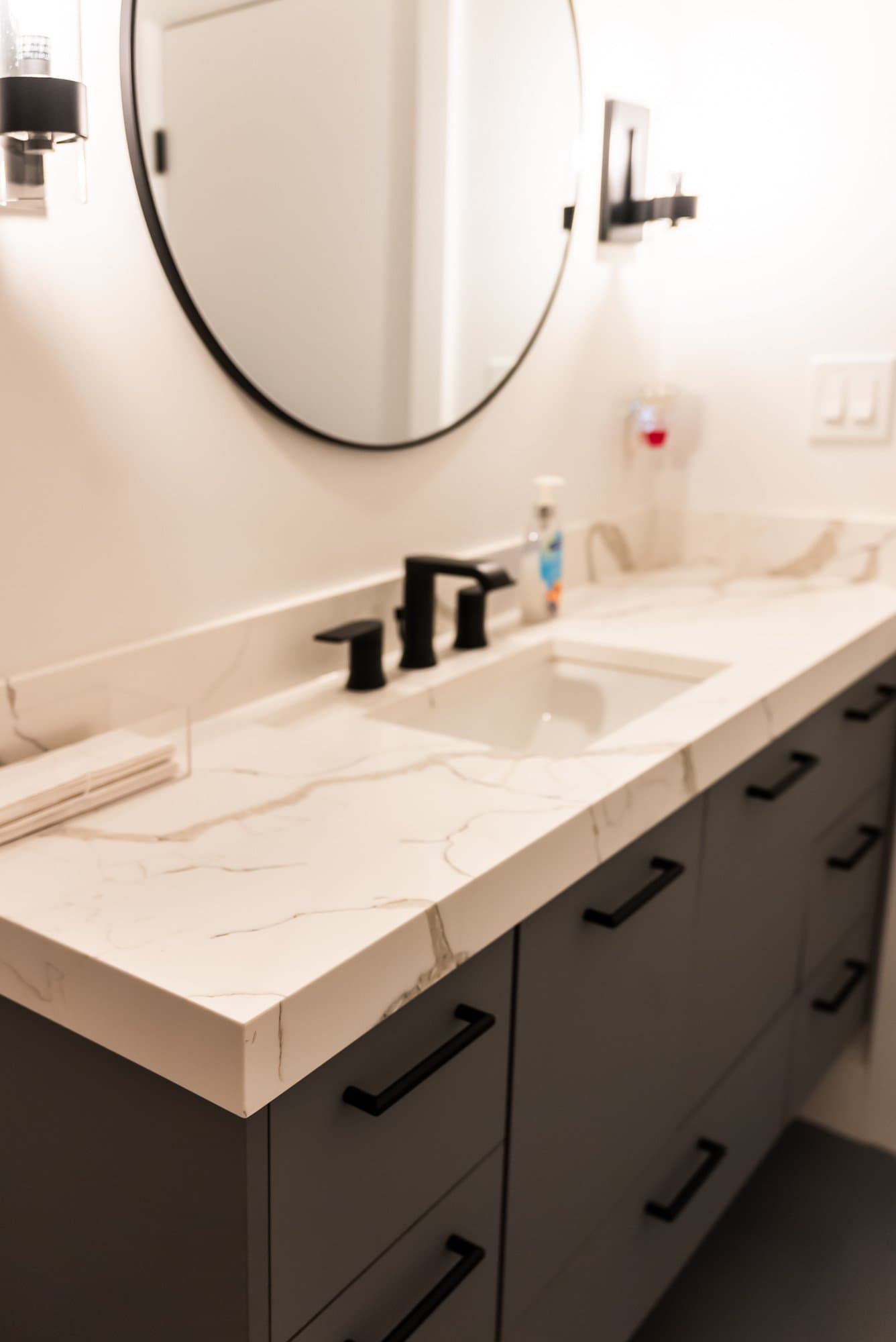 A vanity display with a quartz top and black fixtures in the Bay State Kitchen Gallery showroom