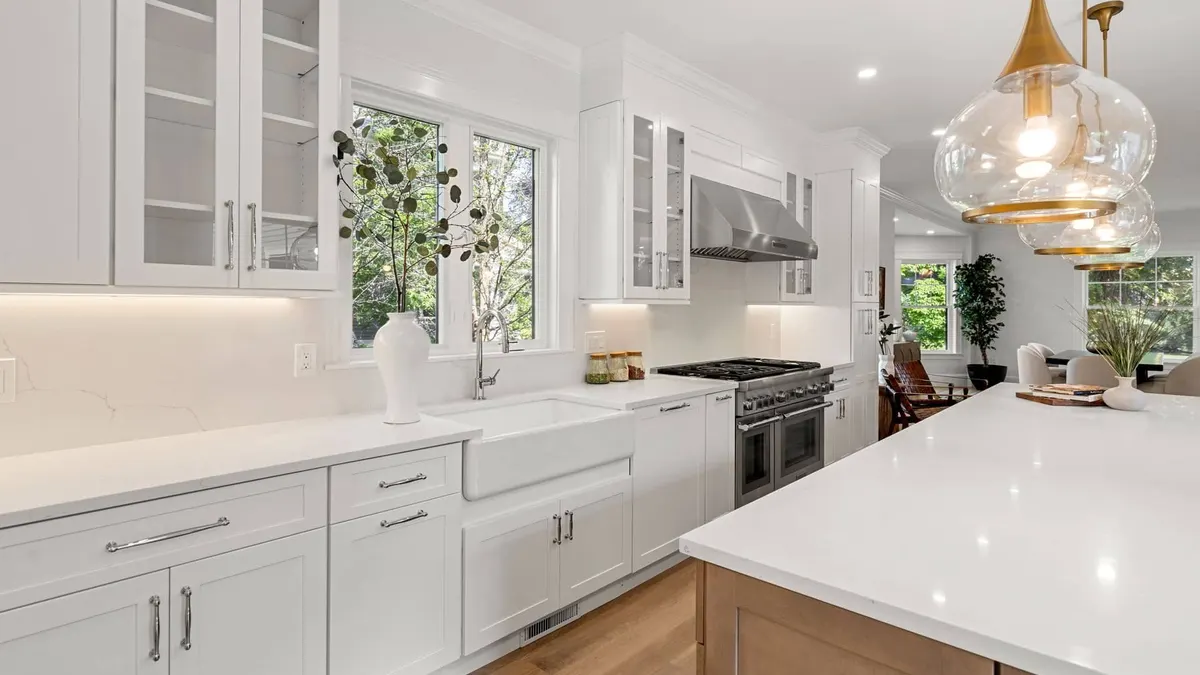 A finished white-and-oak kitchen open to a living room, a Bay State project in Newton
