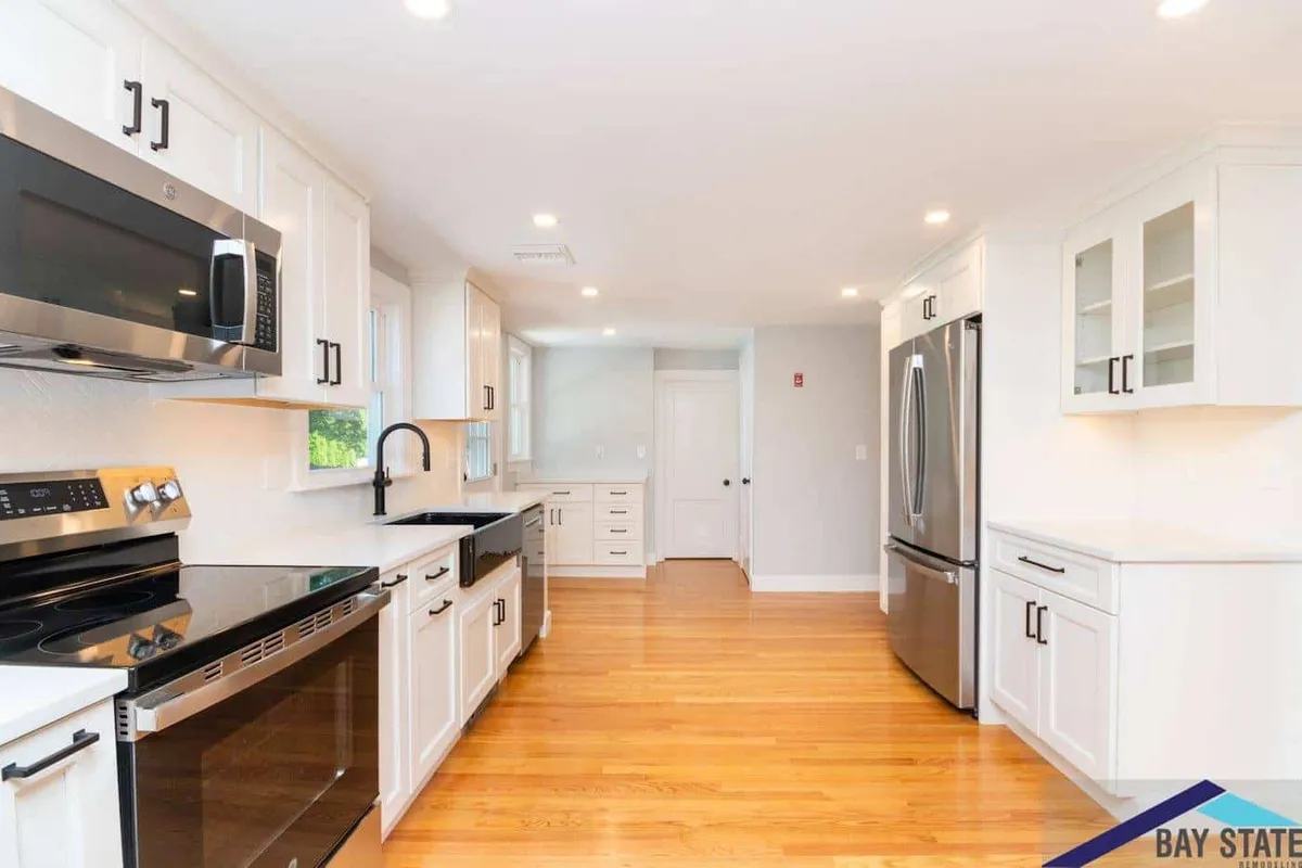 Waltham kitchen with white shaker cabinets, black countertops, and stainless steel appliances throughout