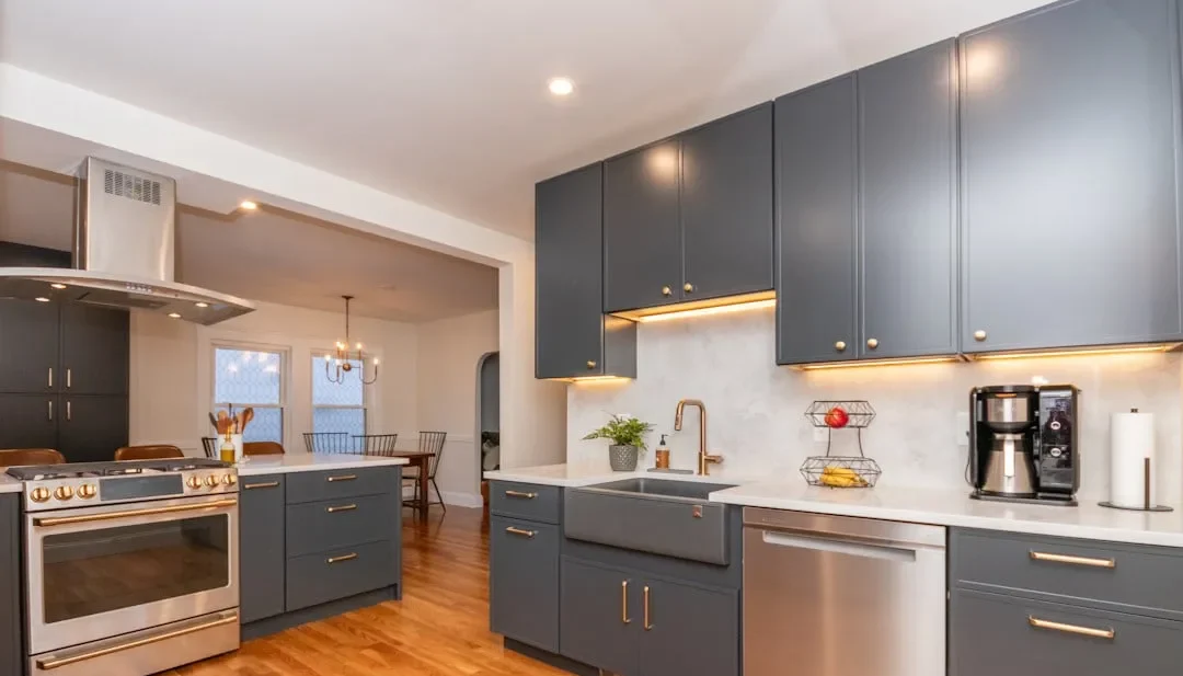 Arlington kitchen with charcoal shaker cabinets, brass hardware, white quartz counters, and a farmhouse sink