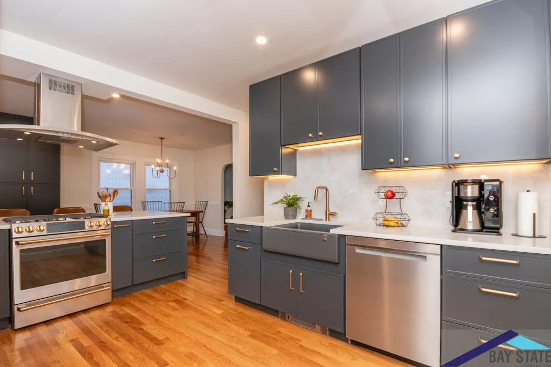 Arlington kitchen with charcoal shaker cabinets, brass hardware, white quartz counters, and a farmhouse sink