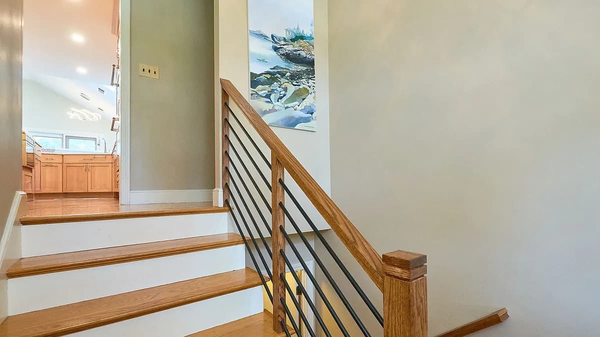 Oak staircase with wood-and-metal railing outside the Wellesley kitchen renovation