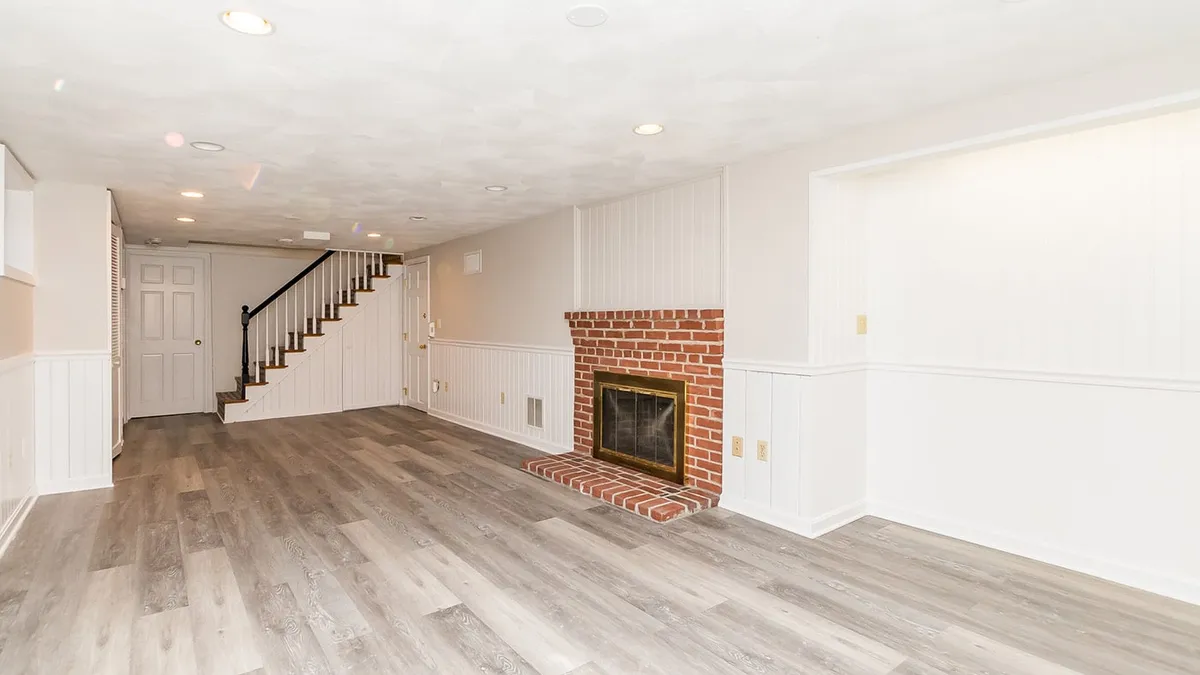 Belmont finished basement with a brick fireplace and wood-look vinyl plank flooring