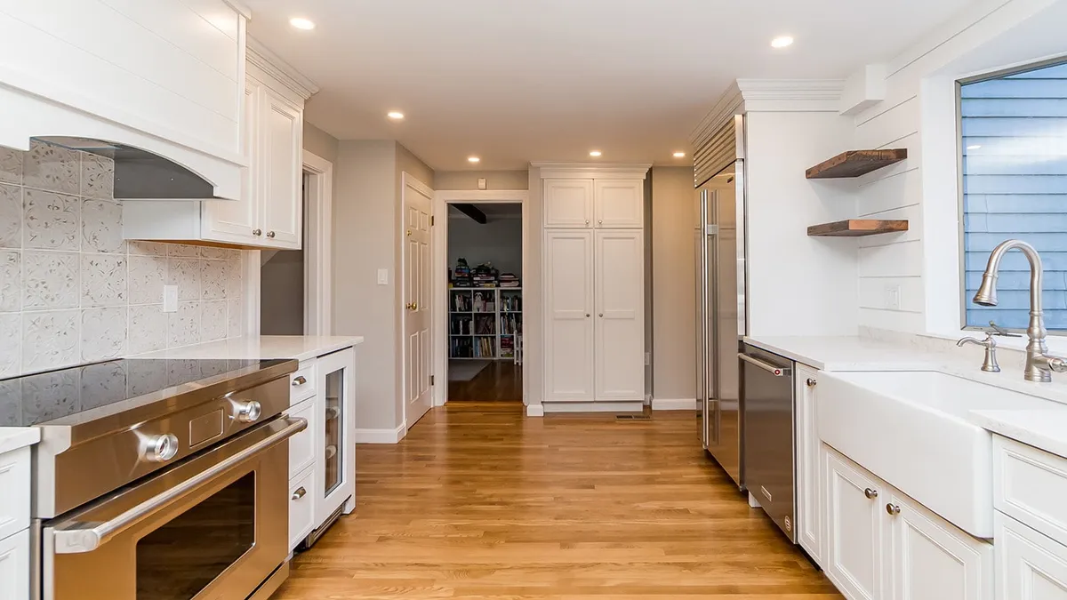 Belmont kitchen with white cabinets, patterned tile backsplash, and a stainless gas range