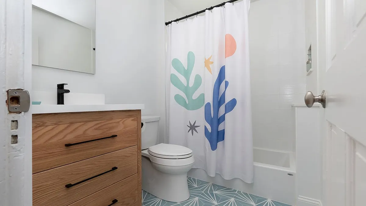 Jamaica Plain bathroom with a wood-tone vanity, white countertop, and a blue patterned tile floor