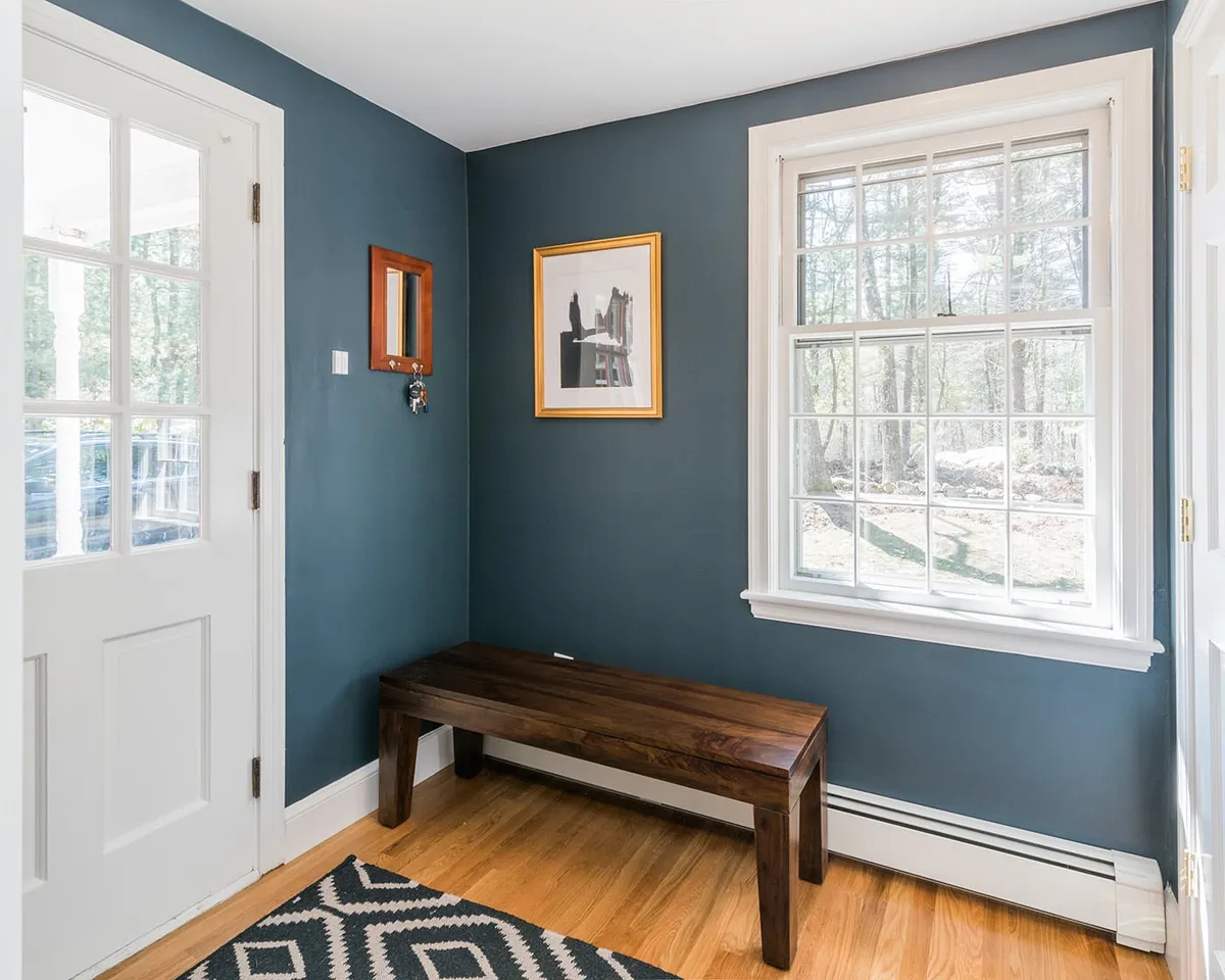 Slate-blue mudroom entry with wood bench and multi-pane window in this Wayland home