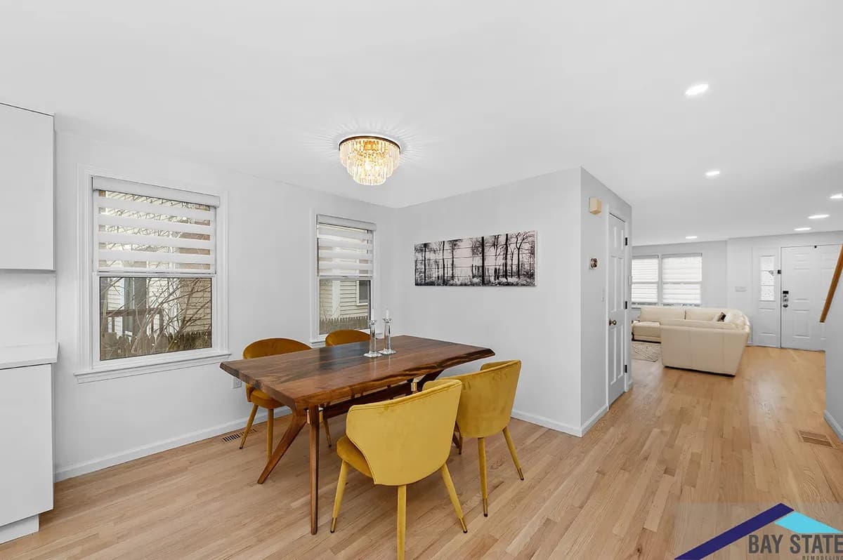 Arlington dining room with a live-edge wood table, mustard velvet chairs, and a crystal chandelier