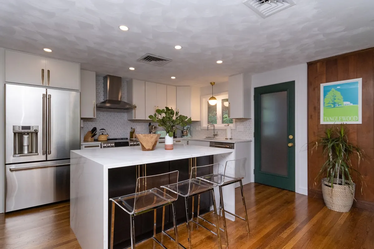 Modern white kitchen with a dark waterfall island — Chestnut Hill