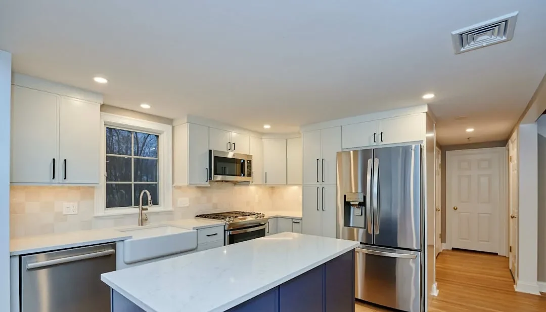 White and navy Arlington kitchen with a gas range, farmhouse sink, and diamond-pattern tile backsplash