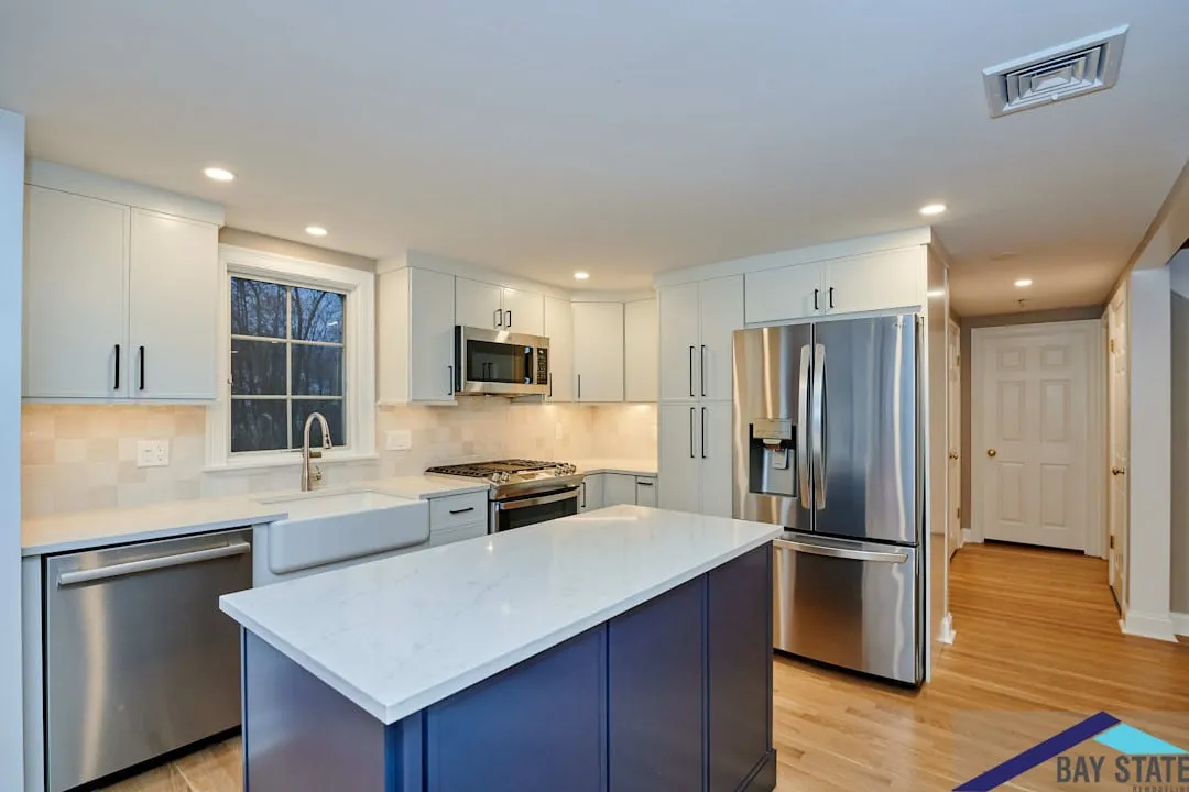 Arlington kitchen with a navy blue island, white shaker cabinets, quartz counters, and a stainless French-door fridge