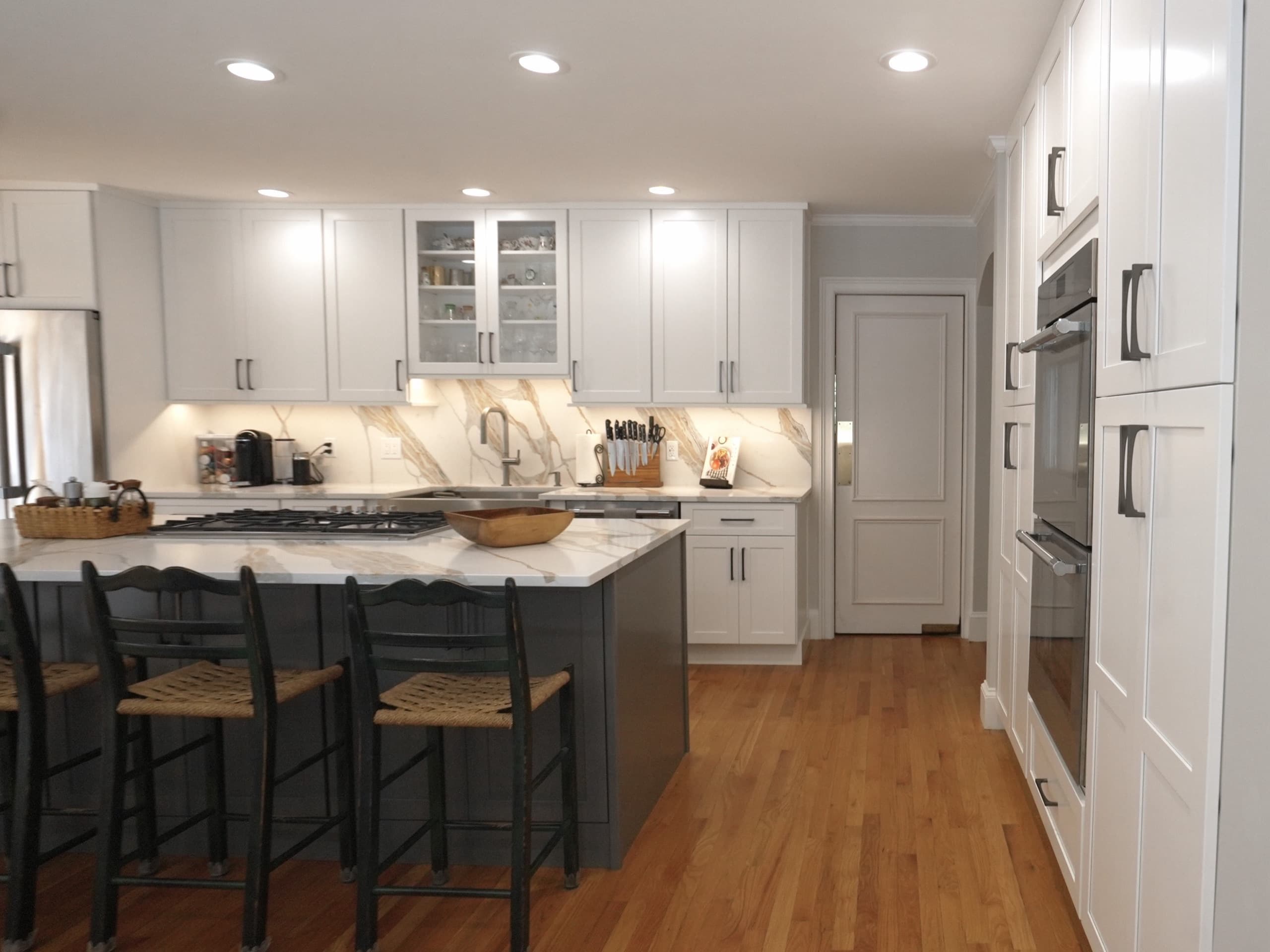 A completed Wayland kitchen with a dark island, bright cabinetry and warm wood floors