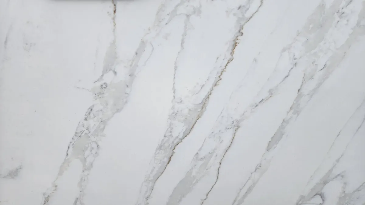 White quartz countertop with warm gold and gray diagonal veining, Calacatta-style pattern
